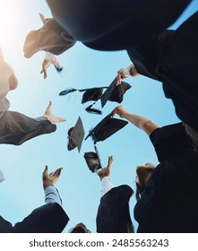 Students, happy and graduation cap in sky on campus with celebration and success. People, college and university classmate or friends with pride or excited for qualification competition in low angle