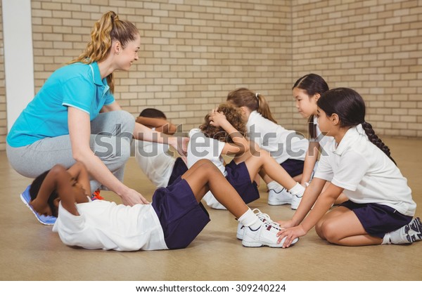 Students helping other students exercise at the\
elementary school