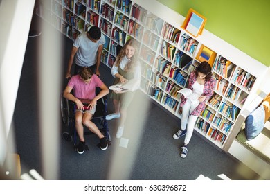 Students interacting with each other in library at school