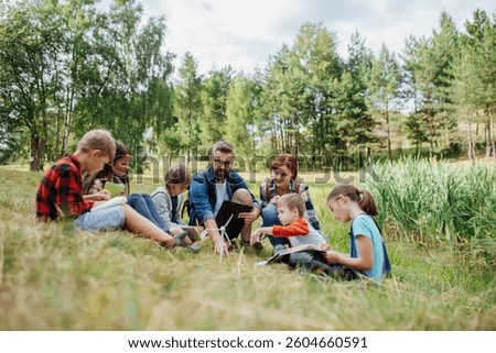 Students learning about renewable wind energy during field teaching class. Outdoor active education helping young student to learn about ecology and sustainability.