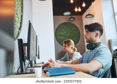 Students Learning In Computer Classroom. Young Man Preparing For Test On Computer. Girl Writing Essay And Making Notes Using Computer. Focused Students Studying For College Exams. Back To School