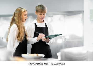 Students are learning to cook in a culinary institute with a standard kitchen and complete equipment. And have a professional chef as a trainer. - Shutterstock ID 2259349993
