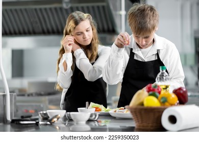 Students are learning to cook in a culinary institute with a standard kitchen and complete equipment. And have a professional chef as a trainer. - Shutterstock ID 2259350023