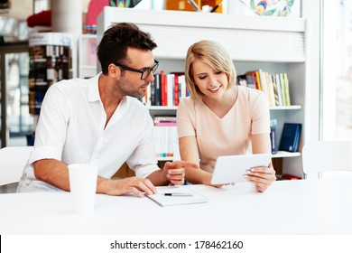 Students In A Library Discussing Test Requirements