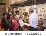 Students Looking At Artifacts In Case On Trip To Museum