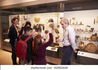 Students Looking At Artifacts In Case On Trip To Museum - Powered by Shutterstock