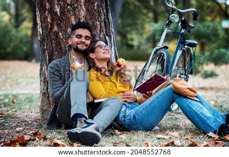 Student's love. Young couple learning together in the autumn park. Education, love and tenderness, dating, romance, lifestyle concept