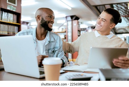 Students, men and library with study support at desk with laptop, tablet and happy for learning opportunity. Student friends, laugh together and vision for university success, diversity and teamwork