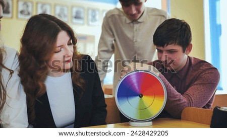 Students in physics class spin Newton's multicolored disk.