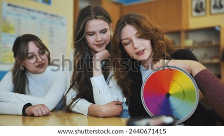 Students in physics class spin Newton's colorful wheel.