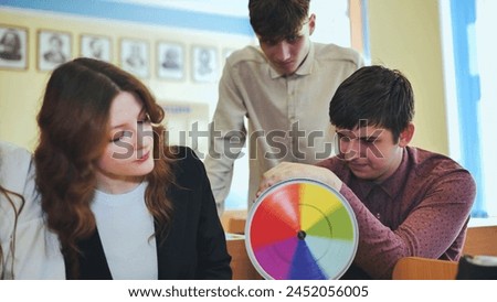 Students in physics class spin Newton's colorful wheel.