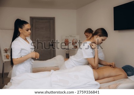 Students practicing back massage in a focused training session, developing professional skills for wellness and therapy careers
