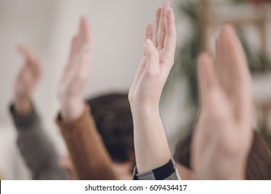 Students Raising Hands In Classroom.