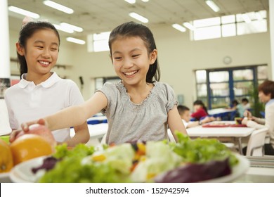 Students Reaching For Healthy Food In School Cafeteria