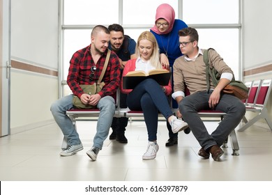Students reading and making notes together in the hall of the University