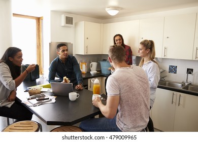 Students Relaxing In Kitchen Of Shared Accommodation