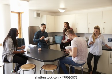 Students Relaxing In Kitchen Of Shared Accommodation