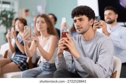 Students scan QR code and use their phone to connect to schools online group. Lecture room is filled with listeners. Company managers during training, professional development courses