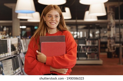 Students, Scholarship And College Concept. Beautiful Redhead Female Studying, Holding Books In Bookstore, Search For Project, Research Material In Library, Smiling Look Bookshelf, Cram For Exam.