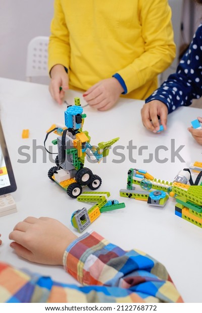 Students In School Computer Coding Class\
Building And Learning To Program Robot Vehicle. Multi ethnic\
children making science, technology and coding tasks at school with\
tablet. Modern\
education