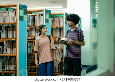 Students selecting reading materials inside library showing independent learning curiosity research habit education journey. Students talking while walking through aisel.
