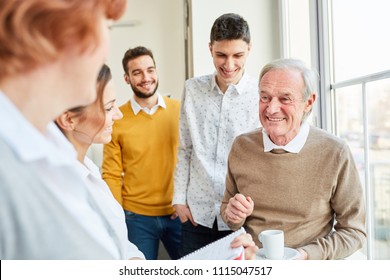 Students And Seniors Making Small Talk In Workshop Break