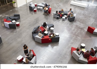 Students Sit In Groups In A Modern University Atrium