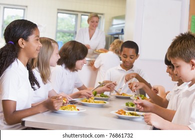 Students Sitting At Cafeteria Table Eating Lunch