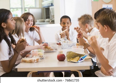 Students Sitting At Cafeteria Table Eating Lunch