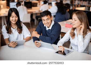 Students studying together in a library, using tablets. Diverse group of young adults collaborating and engaging with technology in an academic setting. Diverse high school students at library.