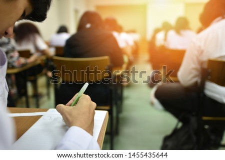 Students taking admission test in exam room at high school, college, or university, education or academic concept picture of professional or vocational learners in training session, selective focus