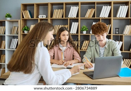 Students teenagers team study using laptop. In the library they review notes, apply learning and teamwork, plan a project and finish homework. Education teamwork study success concept.