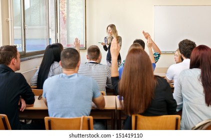 students in their classroom is raising her hand to giving answer - Shutterstock ID 151419110