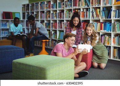 Students using digital tablet in library at school