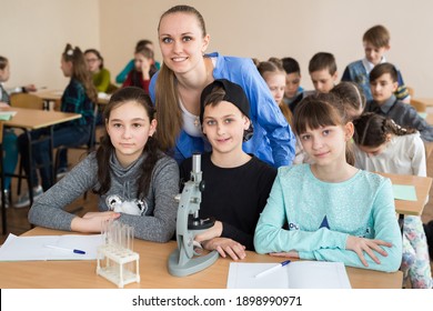 Students using science beakers and a microscope at the elementary school