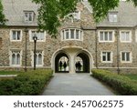 Students walk under gothic arches on the campus of Duke University in Durham NC                               