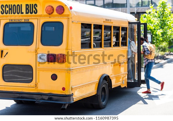 students walking into\
school bus at parking