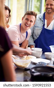 Students Watching Female Teacher Mixing Ingredients In Cookery Class