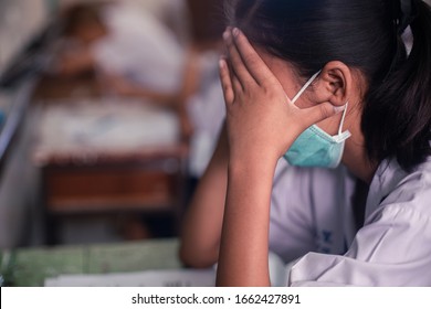 Students Wearing Mask For Protect  Corona Virus Or Covid-19 And Doing Exam Answer Sheets Exercises In Classroom Of School With Stress.