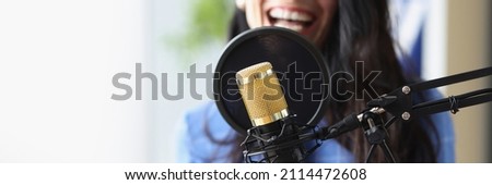 Studio black microphone in background woman sings. Vocal lessons for adults concept