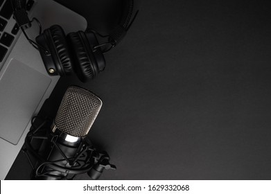 Studio black studio microphone with studio headphones on a laptop on a black background. Banner. Radio, work with sound, podcasts, blogging. - Shutterstock ID 1629332068