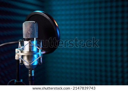 Studio chrome microphone on acoustic foam panel background,