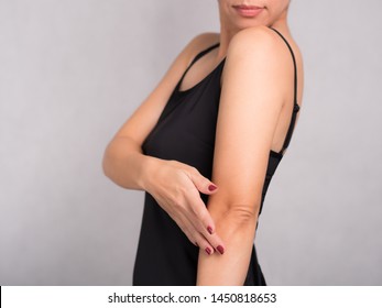 Studio Closeup: Beautiful Woman Model In Black Inner Wear Applying Daily Body Skin Care Cream Lotion On Her Elbow. Rough And Dry, Lack Elasticity, Aging Skin Problem, Dermatology, Beauty Care Concept.