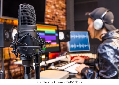 studio condenser microphone on sound engineer working in control room background. recording, broadcasting concept