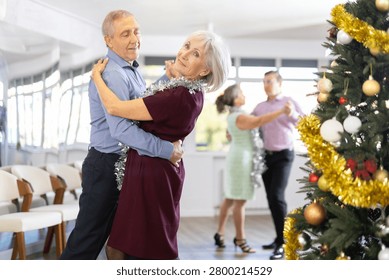 In studio decorated for New Year, elderly man and woman perky dance pair discofox. Energy activity and hobbies