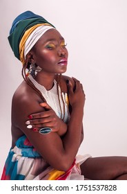 Studio Fashion Portrait Of Young African Woman In Summer Dress And Ethnic Head Wrap, White Background, Sitting Girl, High Heels