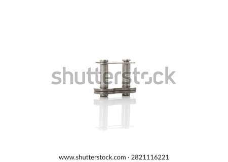 Studio front view of master chain link featuring metallic steel roller pins, connecting side plates, retaining clip, soft bottom mirror reflection, and professional lighting on isolated white background for motorcycle drive chain overhaul.