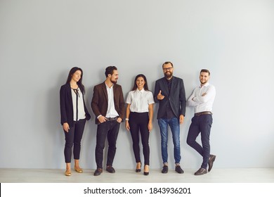 Studio Group Portrait Of 5 Happy Smiling Business Men And Women. Young Team Of Managers Standing In Office Looking At Camera At Corporate Work Event. Start-up Members Or Company Staff Gather Together