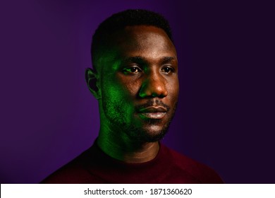 Studio Head Shot Of Stoic Black Man With Light Reflecting Off Face. Isolated Background. Portrait. 