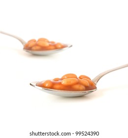 Studio Image Of Baked Beans On Steel Spoon Montage. Focus On The Foreground. Copy Space.